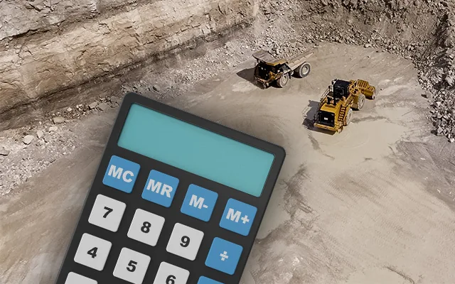 Calculator over a quarry floor with a haul truck and wheel loader working in the background