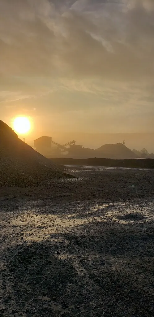 Sun setting over an Appalachian Aggregates quarry and stockpiles